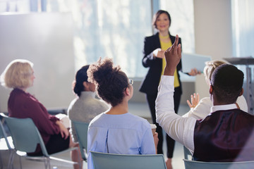 Businesswoman leading conference presentation, answering audience questions