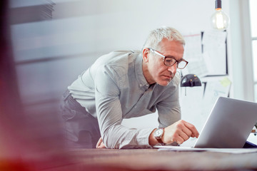Serious, focused businessman working at laptop in office