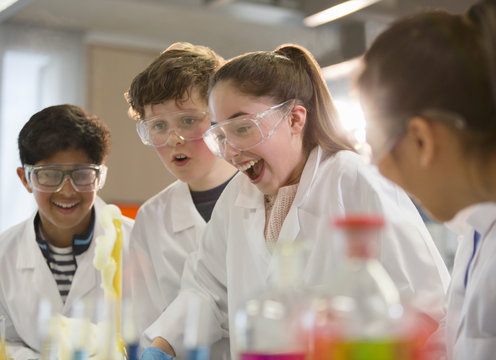 Surprised students conducting exploding foam scientific experiment in classroom laboratory