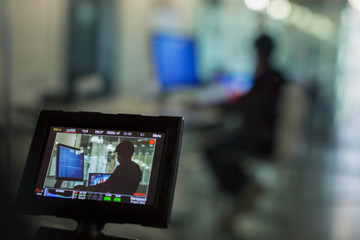 View of boy programming at computer in classroom on digital camera viewfinder 