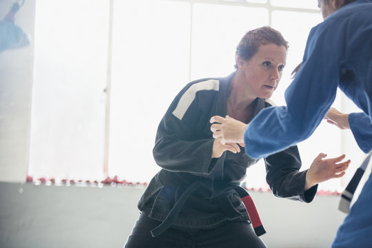 Determined, tough woman practicing judo in gym