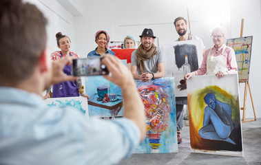 Man photographing art class classmates in art studio