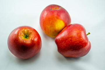 three red apples on a white background