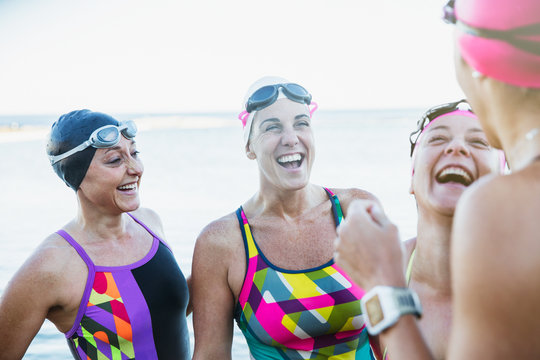 Laughing female open water swimmers talking