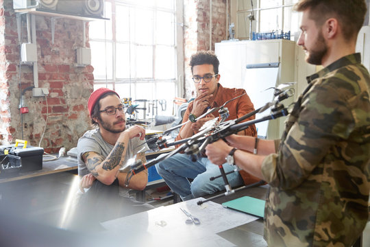 Designers meeting, examining drone in workshop