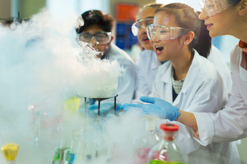 Surprised, curious students watching chemical reaction, conducting scientific experiment in laboratory classroom