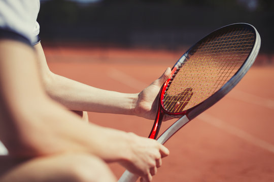 Young male tennis player holding tennis racket