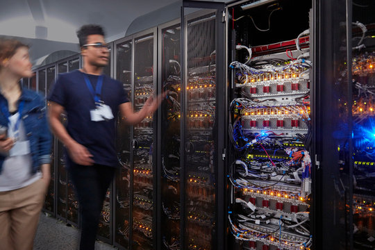 IT technicians walking along panels in server room