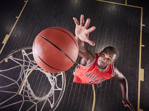 Overhead view young male basketball player jumping to rebound the ball on basketball rim