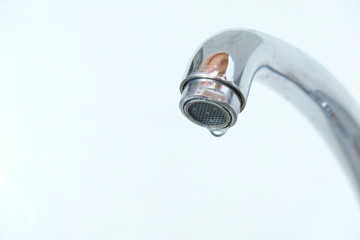 A close up of a  water drop on the faucet