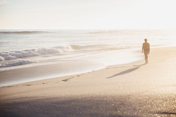 Silhouette woman walking on idyllic sunny summer beach