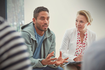 Young man talking in group therapy session