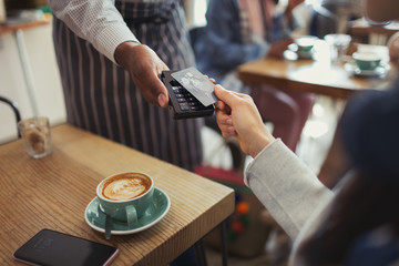 Customer credit card paying worker contactless payment in cafe