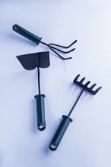 Short garden tool flat lay. Rakes and trowel, white isolated background.