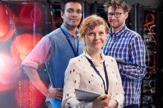 Portrait confident IT technicians with digital tablet in server room