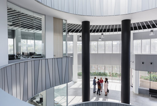 Business people talking in architectural, modern office atrium