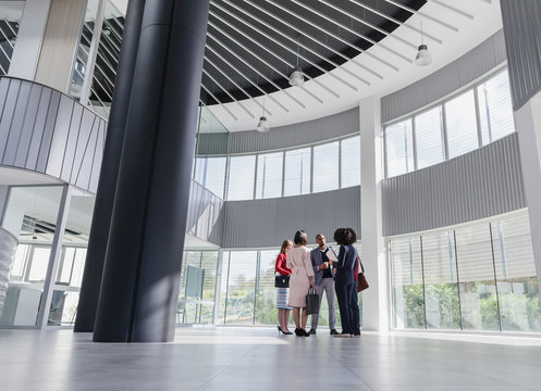 Business People Talking In Architectural, Modern Office Lobby