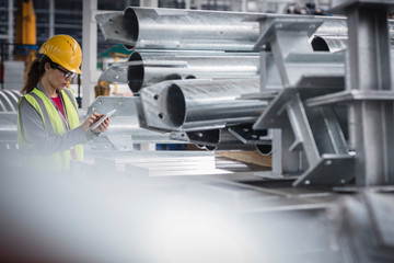 Female supervisor with digital tablet working in steel factory
