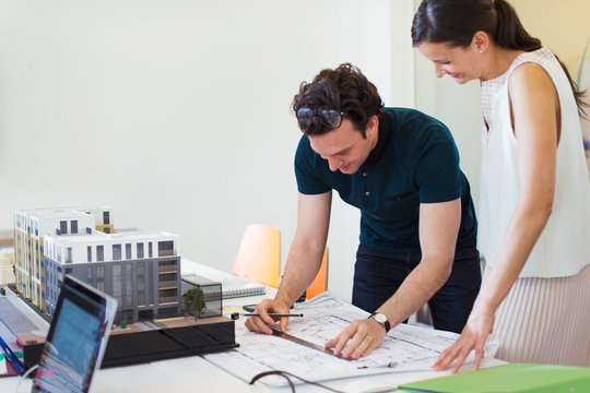 Architects drafting blueprint in office