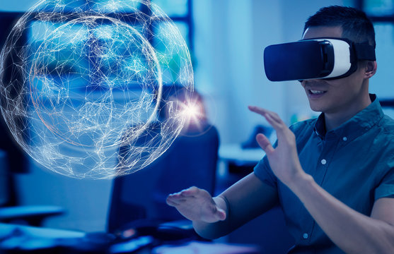Computer programmer testing virtual reality simulator glasses, viewing projection hologram
