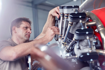 Male airplane mechanic repairing propellor