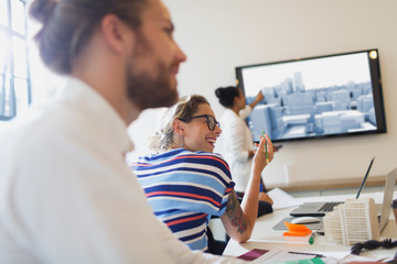 Smiling female architect talking in conference room meeting
