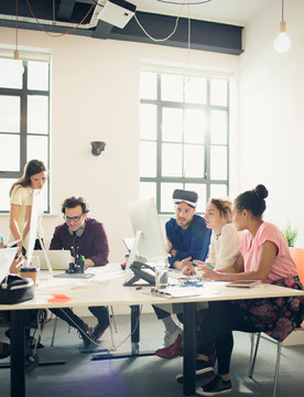 Computer programmers programming virtual reality simulator glasses in office