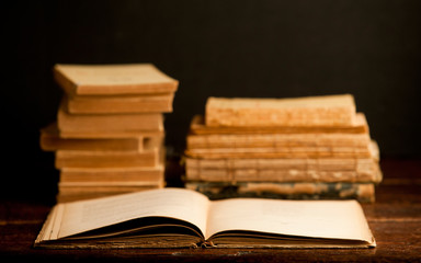 old books on wooden desk, with open book