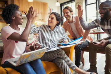 Creative business people high-fiving in meeting