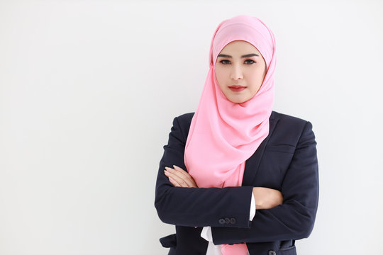 Pretty muslim young asian woman wearing blue suit smiling confident in studio. Isolated white background portrait with beautiful face girl with pink hijab. Advertisement portrait concept.