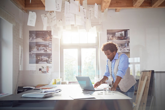 Male graphic designer working at laptop in office