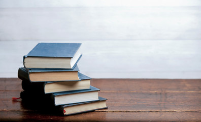 stack of blue books on old wooden shelf with dark background