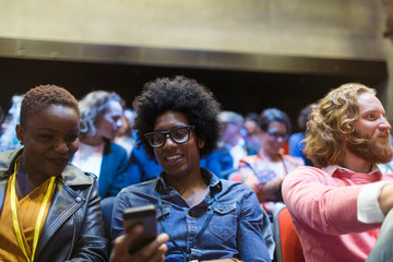 Business people using smart phone in conference audience