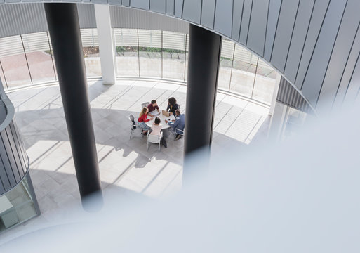 Business people meeting at table in modern office atrium - Powered by Adobe