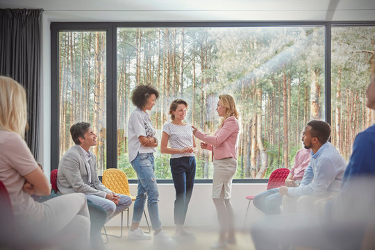 Women standing and talking in group therapy session