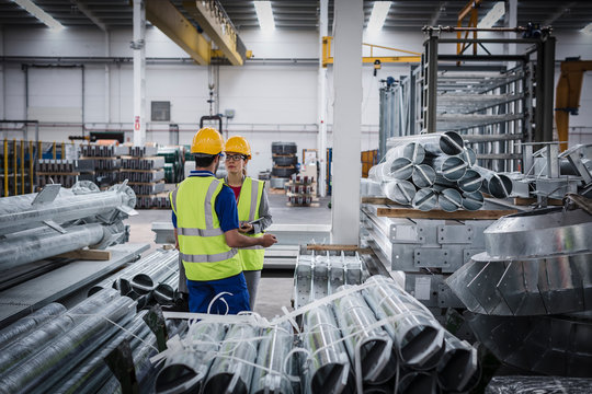 Workers talking in steel factory