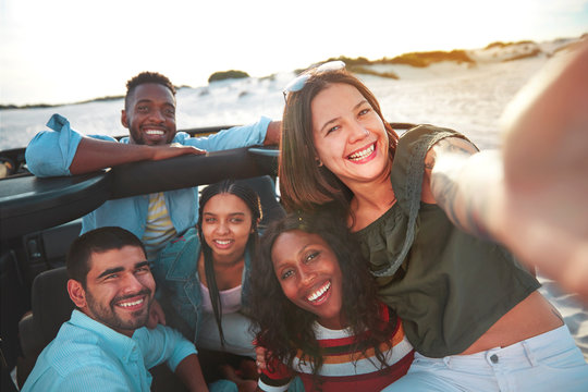 Portrait smiling young friends taking selfie at beach