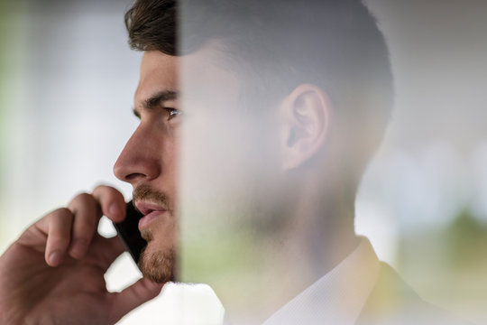 Close up profile serious businessman talking on smart phone, looking away