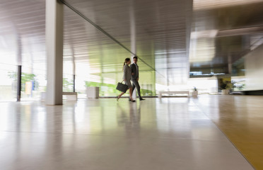 Business people walking in modern office corridor