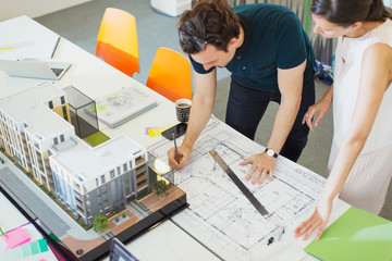 Architects drafting blueprint in office