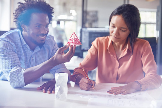 Design professionals examining triangle prototype sketching in office