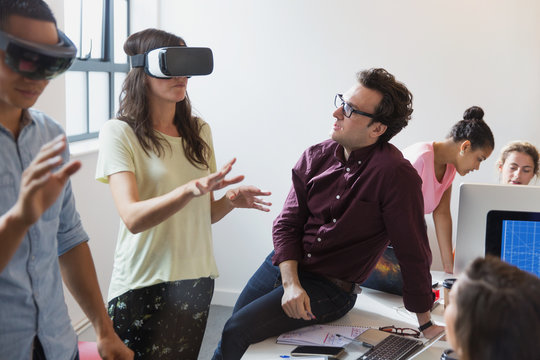 Computer programmers testing virtual reality simulator glasses in office