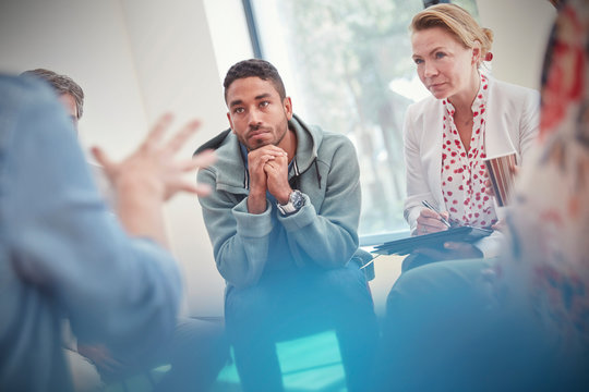 Attentive man and woman listening in group therapy session