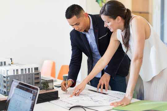 Architects drafting blueprint in office