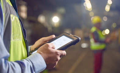 Close up steelworker supervisor using digital tablet in steel mill