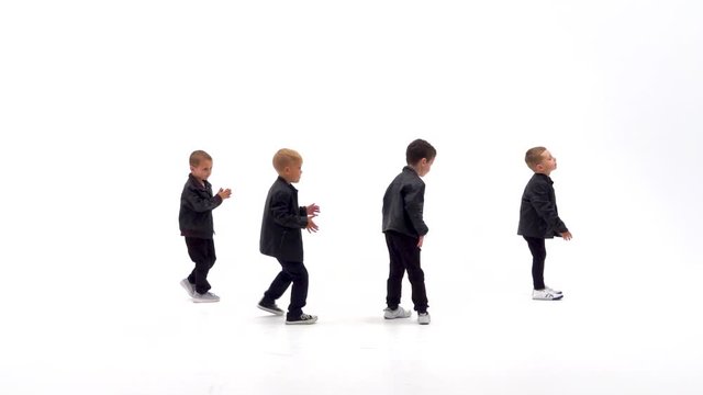 Kids are dancing a modern dance on the white background in black leather jackets and jeans. Slow motion