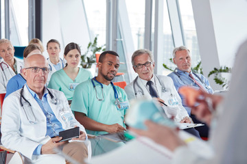 Surgeons, doctors and nurses listening in conference audience