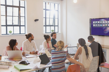 Architects using television screen in conference room meeting
