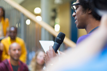 Businessman speaker microphone digital tablet talking at conference