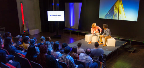 Audience watching speakers talking on stage